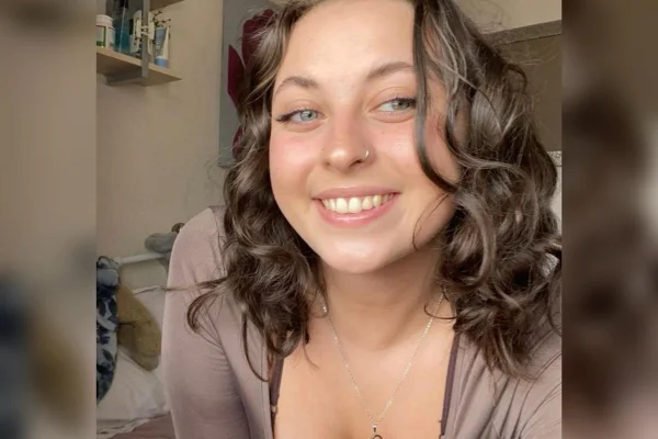 Foto da personagem Esther Littlewood sorrindo. Ela é branca, tem olhos claros, usa percing no nariz e cabelos castanhos ondulados. Metrópoles