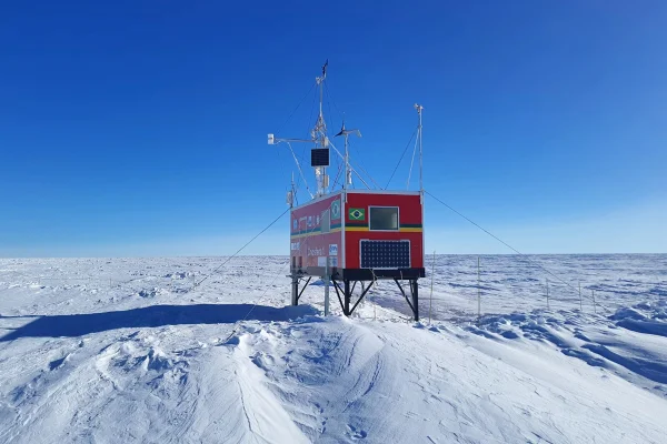 Foto colorida de um laboratório brasileiro de cor vermelha, situado em um campo deserto na Antártica - Metrópoles.