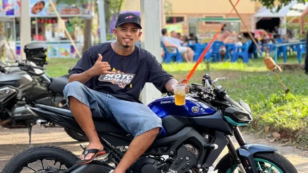 Foto colorida de Eduardo Felipe Alves da Cruz e Silva sentado em uma segurando uma bebida - Metrópoles