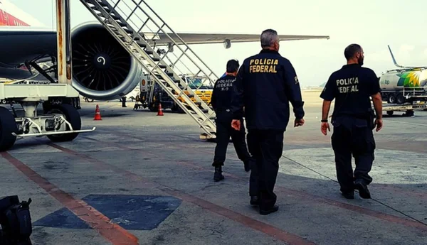 Imagem colorida mostra agentes da Polícia Federal durante ação que prendeu duas mulheres no aeroporto de Guarulhos, em São Paulo - Metrópoles