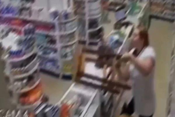 Foto colorida de mulher dando cadeirada em assaltante