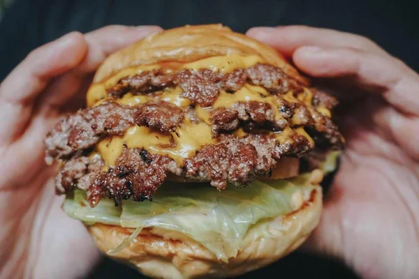 mãos seguram smash burguer
