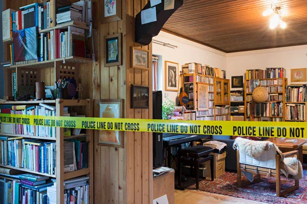 Foto mostra biblioteca, sala com muitos livros, com faixa de polícia na frente - Metrópoles