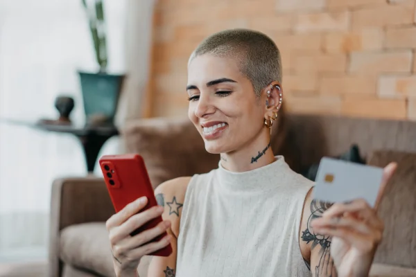 Mulher fazendo compras pela internet em smartphone usando cartão de crédito