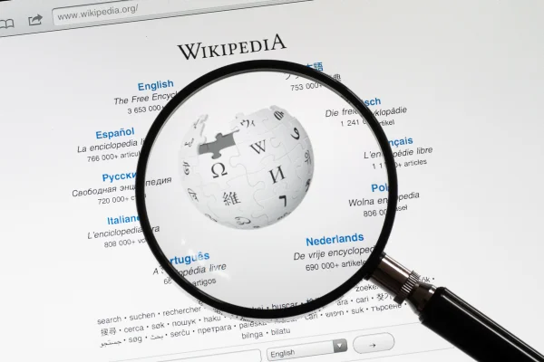 Utrechyt, Países Baixos - 12 de junho de 2011: Uma lupa na página inicial da Wikipédia. A Wikipédia é uma enciclopédia online gratuita à qual voluntários podem adicionar artigos.