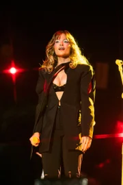 Na primeira roupa da noite, Luísa Sonza apostou em um look all black, com blazer preto e sutiã à mostra
