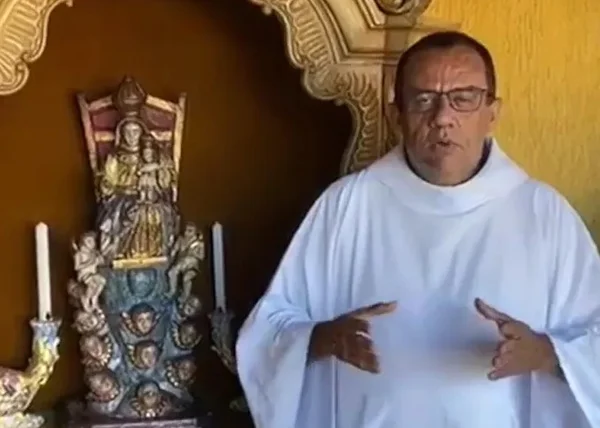 Foto colorida de padre Egídio da Paraíba ao lado de imagem sacra - Metrópoles