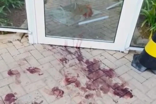 Imagem colorida de marcas de sangue na entrada de condomínio. Metrópoles
