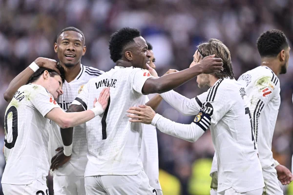 Foto colorida de Vini Jr. com a equipe do Real Madrid comemorando gol contra o Rayo - Metrópoles