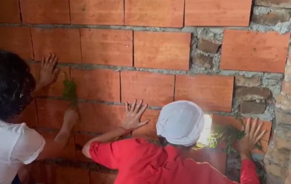Imagem mostra pessoas em frente a um muro de blocos - Metrópoles