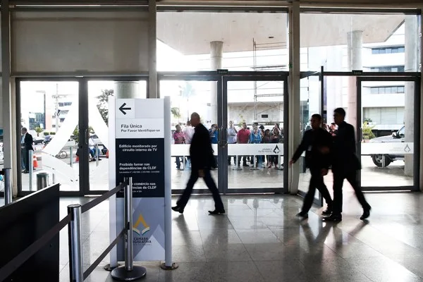 Pessoas caminham em saguão