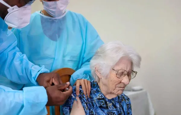 Foto colorida de uma idosa recebendo a vacina bivalente da Covid-19 - Metrópoles