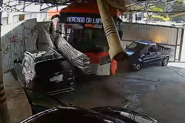 Câmeras registraram o momento em que o ônibus derruba tapume e invade estacionamento. Ninguém ficou gravemente ferido - Metrópoles