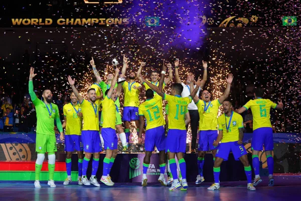 Imagem colorida da Seleção Brasileira levantando a taça da Copa do Mundo de Futsal - Metrópoles
