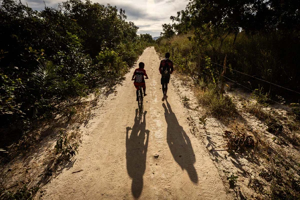 Imagem de dois meninos andando para a escola na estrada de terra em cavalcante