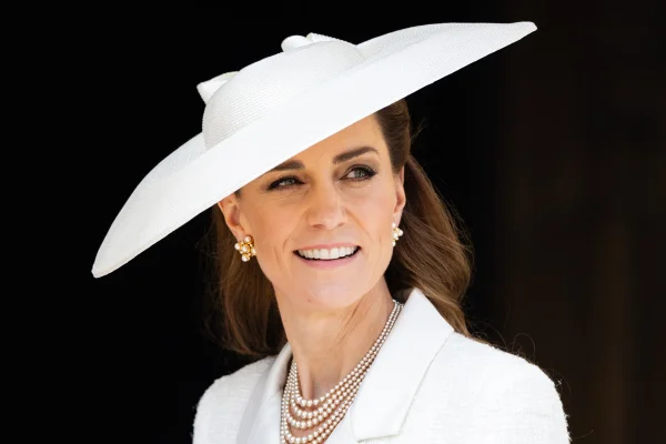 Foto colorida de mulher com chapéu branco, colares e par de brincos - Metrópoles