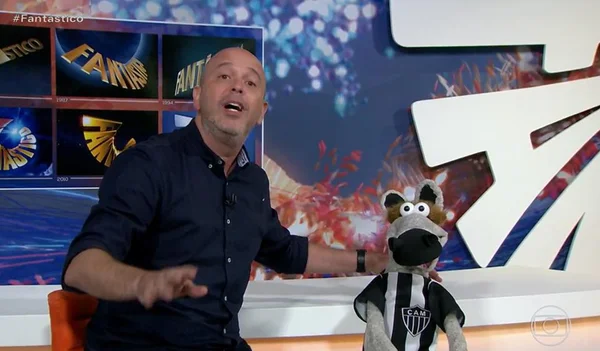 Alex Escobar na apresentação do Fantástico ao lado de um cavalinho da Globo - Metrópoles