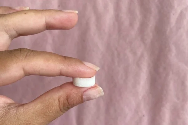 Mão de mulher segura medicamento - Metrópoles