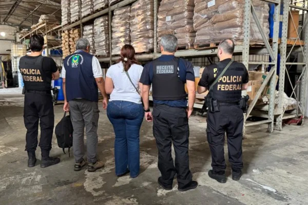 Foto colorida mostra agentes da Polícia Federal, da ANP e do Ministério da Agricultura durante operação contra fábricas clandestinas de bebidas falsificadas