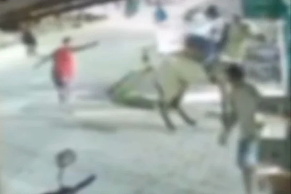 Foto colorida, homem efetuando disparos, pessoas correndo - Metrópoles