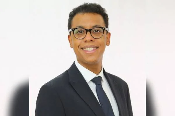 Advogado Nauê Bernardo, vítima de racismo no STF ao ser confundido por um segurança com um motorista. Ele é negro, usa óculos pretos e terno, sorrindo - Metrópoles