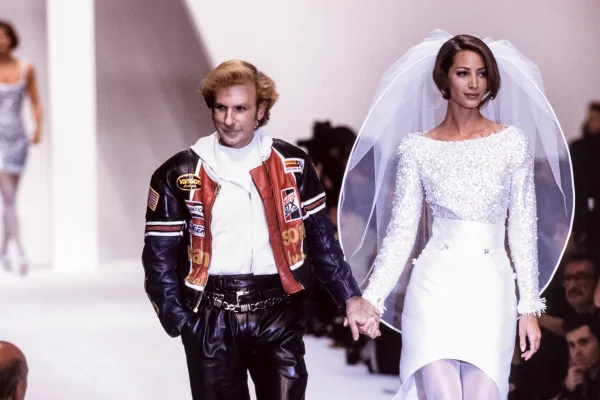 Estilista Claude Montana na passarela com a modelo Christy Turlington, em 1991. Ela usa um vestido branco bordado de noiva com véu - Metrópoles