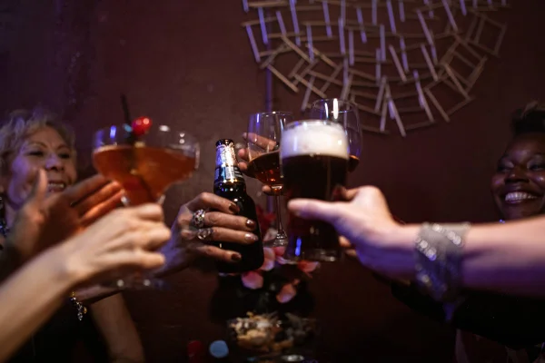 Várias pessoas brindando com copos e drinks - Metrópoles