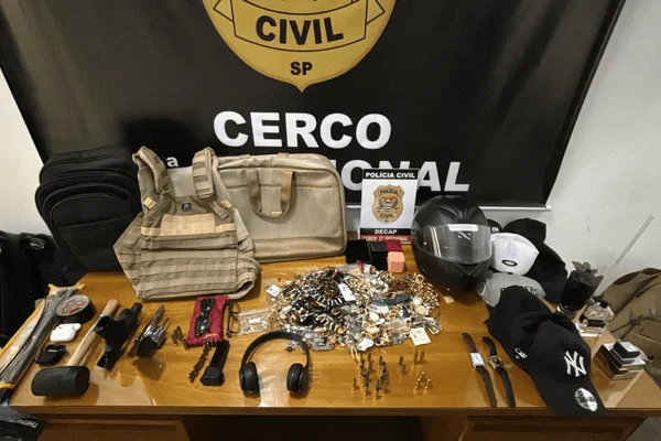 Imagem colorida de diversos itens apreendidos em uma mesa da Polícia Civil - Metrópoles