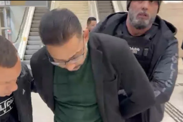 Foto colorida do momento em que suspeito de ser líder de "arrastadores", no Aeroporto Internacional de Guarulhos, foi preso pela Polícia Civil.