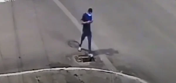 homem andando pela rua cai em bueiro