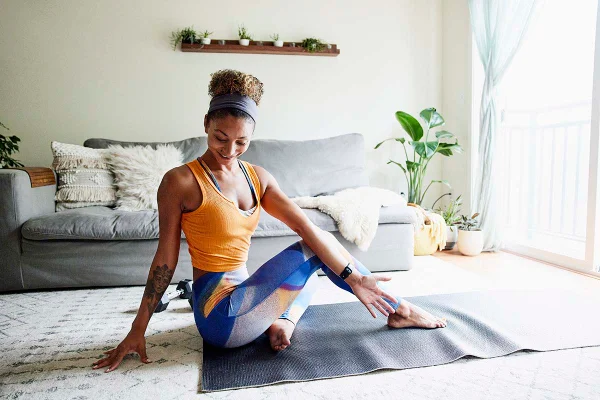Mulher com roupa de malhar fazendo exercício em casa