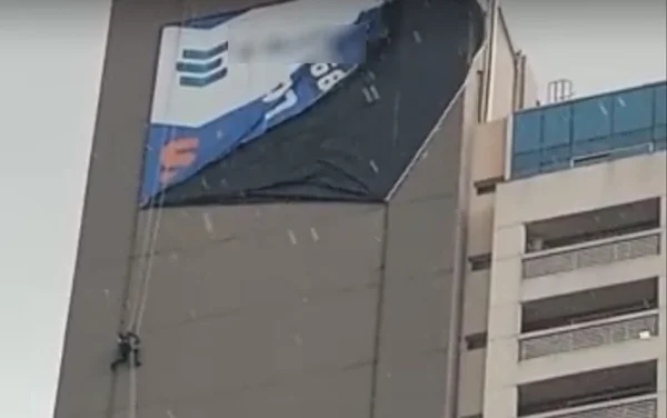 Alpinista industrial fica presa em prédio durante forte temporal