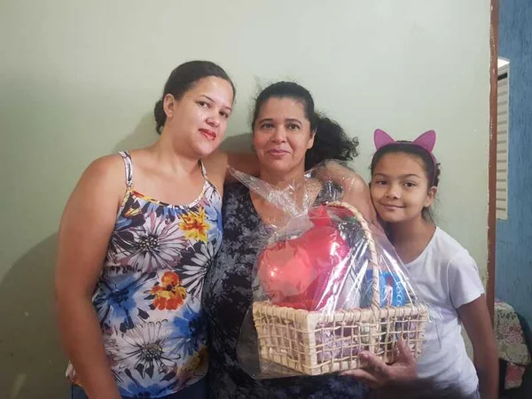 Mãe sorri para foto com filha e neta