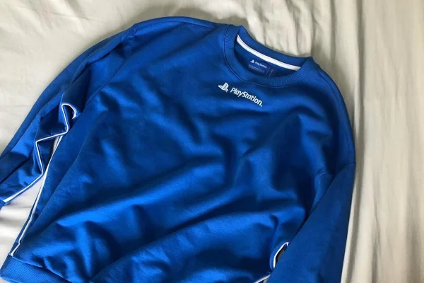 Na imagem com cor, moletom azul da Renner com a PlayStation 5