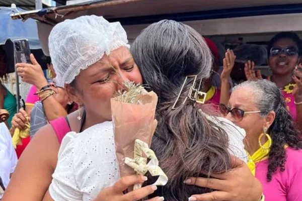 Foto colorida de duas mulheres se abraçando e chorando