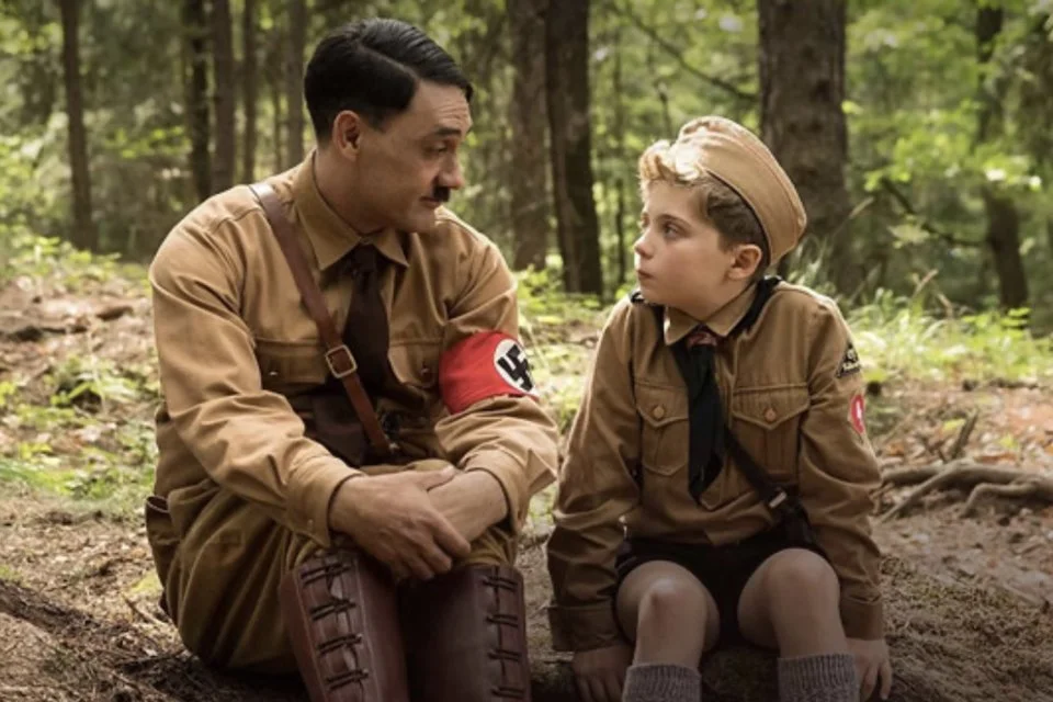 <b>Jojo Rabbit</b>. Na Alemanha, durante a Segunda Guerra Mundial. Jojo (Roman Griffin Davis) é um jovem nazista de 10 anos, que trata Adolf Hitler (Taika Waititi) como um amigo próximo, em sua imaginação. Seu maior sonho é participar da Juventude Hitlerista, um grupo pró-nazista composto por outras pessoas que concordam com os seus ideais. Um dia, Jojo descobre que sua mãe (Scarlett Johansson) está escondendo uma judia (Thomasin McKenzie) no sótão de casa. Depois de várias tentativas frustradas para expulsá-la, o jovem rebelde começa a desenvolver empatia pela nova hóspede. <a href="https://www.youtube.com/watch?v=IsLaqpsxaZY" target="_blank">Veja trailer</a> <b>Jojo Rabbit</b>. Na Alemanha, durante a Segunda Guerra Mundial. Jojo (Roman Griffin Davis) é um jovem nazista de 10 anos, que trata Adolf Hitler (Taika Waititi) como um amigo próximo, em sua imaginação. Seu maior sonho é participar da Juventude Hitlerista, um grupo pró-nazista composto por outras pessoas que concordam com os seus ideais. Um dia, Jojo descobre que sua mãe (Scarlett Johansson) está escondendo uma judia (Thomasin McKenzie) no sótão de casa. Depois de várias tentativas frustradas para expulsá-la, o jovem rebelde começa a desenvolver empatia pela nova hóspede. <a href="https://www.youtube.com/watch?v=IsLaqpsxaZY" target="_blank">Veja trailer</a>