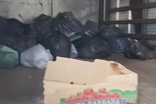 Imagem colorida de lixo dentro de caminhão. Metrópoles