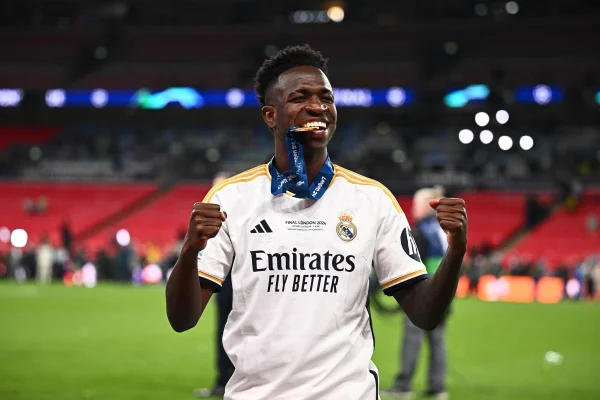 Foto colorida de Vini Jr. sorrindo com a medalha da Champions League - Metrópoles