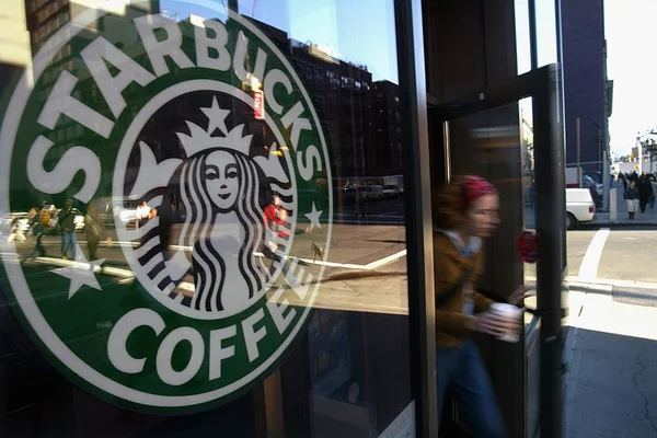 Imagem da porte de uma loja da Starbucks, com uma pessoa saindo - Metrópoles