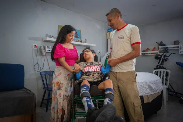 Imagem colorida de uma criança com doença rara ao lado de familiares- Metrópoles