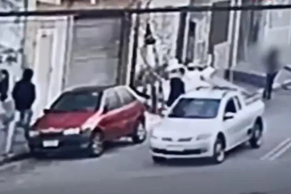Imagem colorida de homem encapuzado seguindo adolescente; suspeito esfaqueou a garota pelas costas - Metrópoles