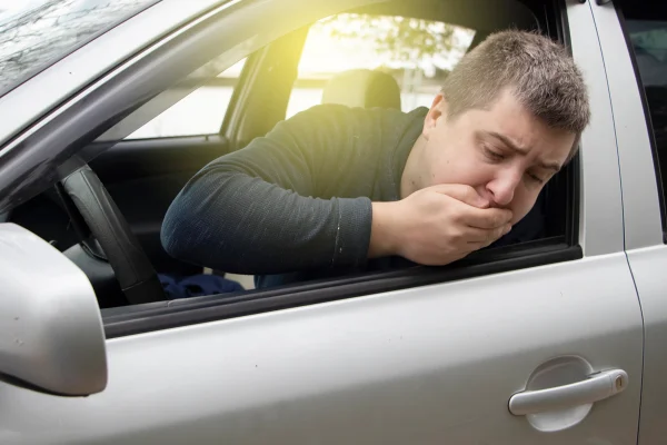 Imagem colorida mostra homem branco dentro de um carro passando mal - Metrópoles