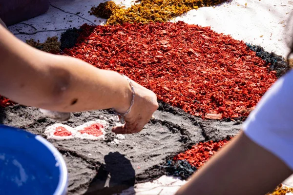Imagem colorida de jovens montando tapetes em celebração ao Corpus Christi - Metrópoles