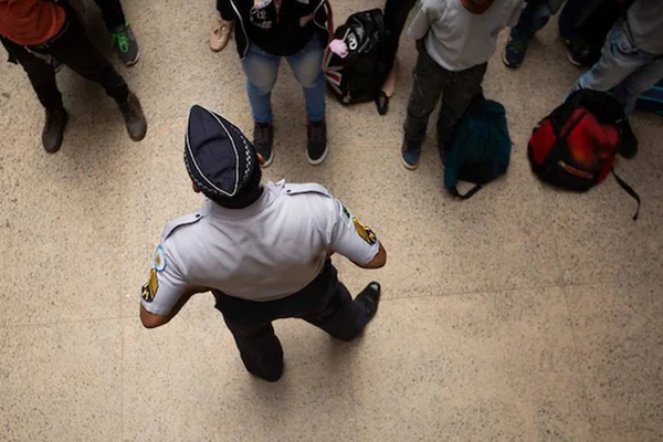 Policial militar e alunos em escola militarizada - Metrópoles
