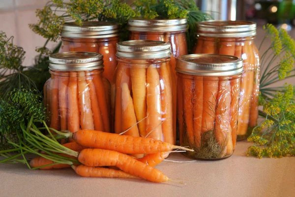 Endro cenouras em potes com ingredientes frescos no balcão da cozinha.