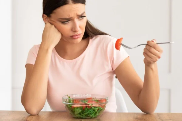 mulher comendo falada e fazendo cara feia