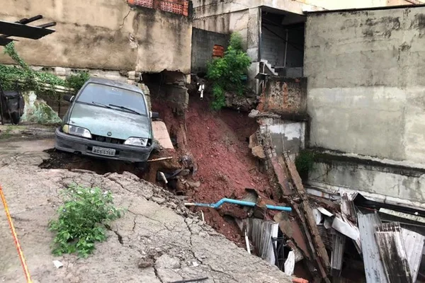Após chuva, muro de condomínio desaba e cratera engole carros