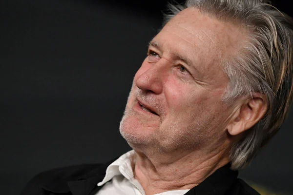 Foto colorida do ator Bill Pullman olhando para o lado em tapete vermelho - Metrópoles