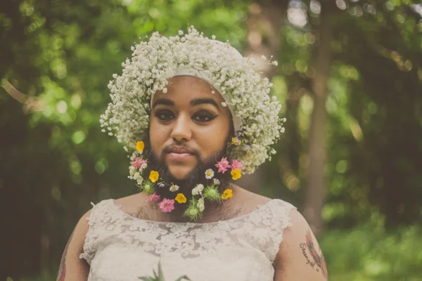 Com síndrome hormonal, mulher posa com barba enfeitada de flores para revista de noivas