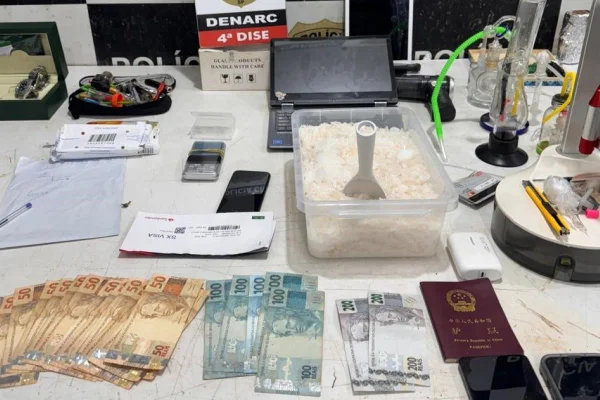 Mesa do Denarc com o que foi apreendido na operação, como metanfetamina, notas de cinquenta, cem e duzentos reais